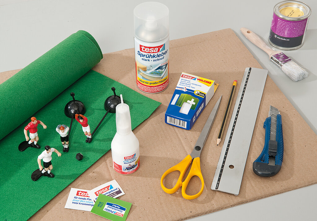 Tipp Kick basteln: Übersicht der benötigten Materialien wie Pappe, Filz, Kleber, Cuttermesser