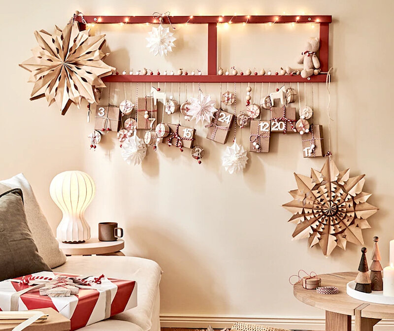 Vom Regal zum Adventskalender: Selbst gebauter Wandkalender aus einem alten Holzregal mit 24 kleinen Geschenken, Lichterkette und weihnachtlicher Dekoration.