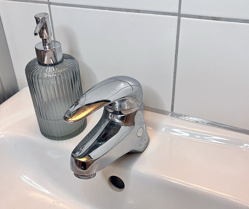 Silikonfugen auffrischen am Waschbecken – fertige, gleichmäßige Fuge zwischen Keramik und Fliesen.