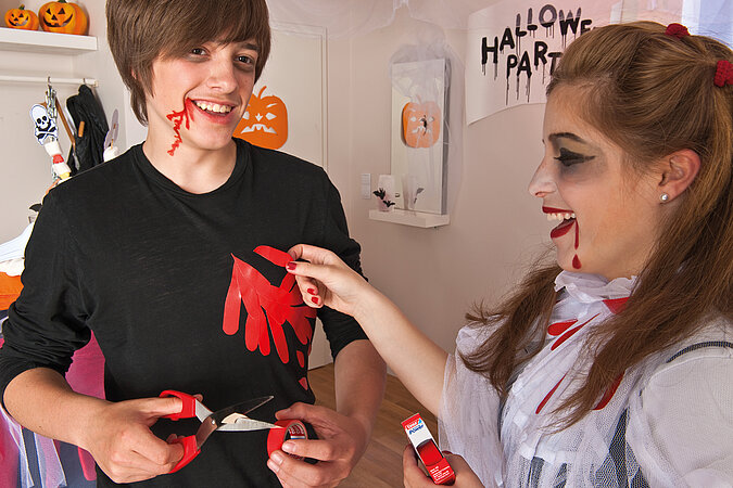 Halloween-Kostüm selber machen: Mit roter Farbe und einem Handabdruck auf dem schwarzen T-Shirt entsteht ein blutiges Mordopfer-Kostüm.