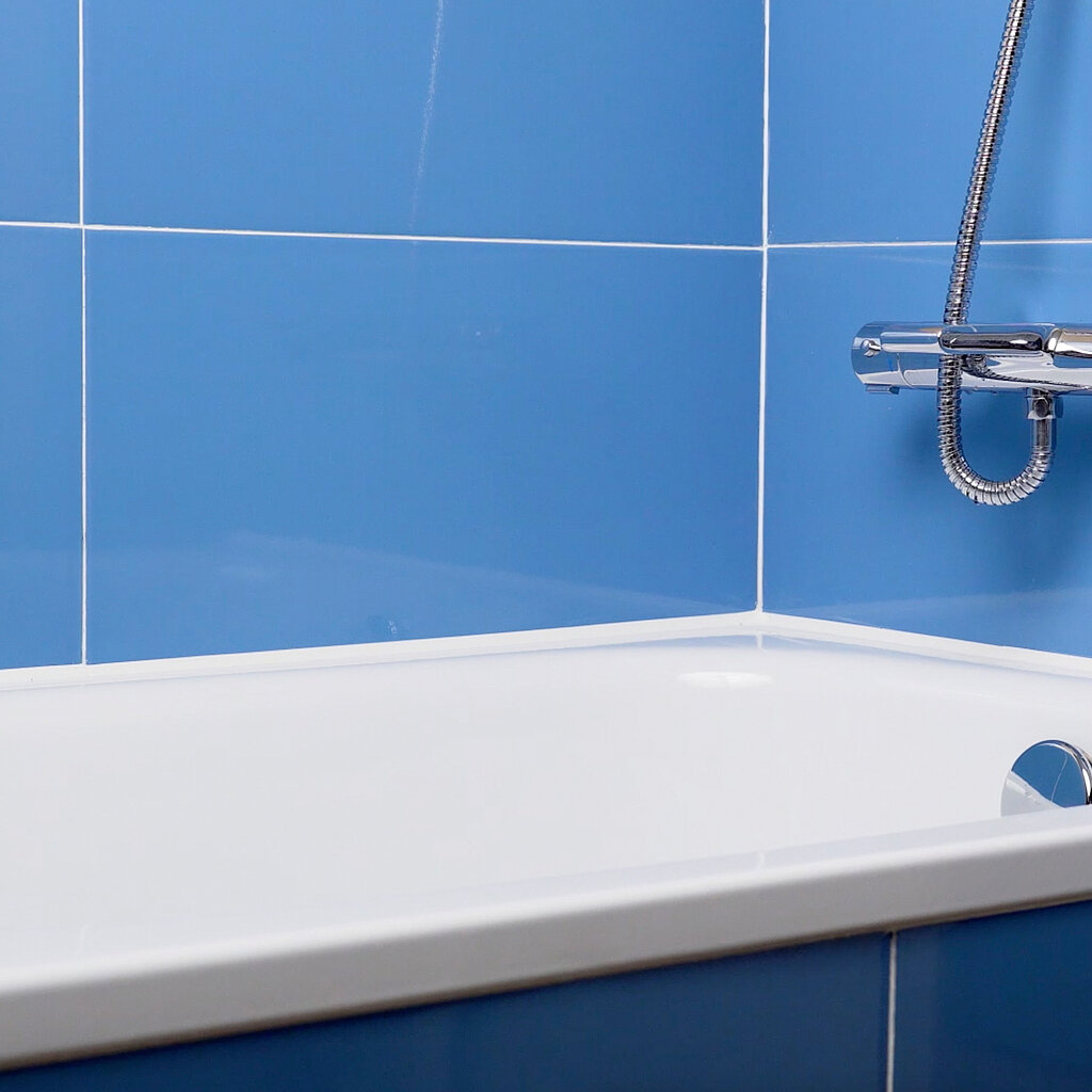 Frische Silikonfuge am Badewannenrand mit blauen Wandfliesen