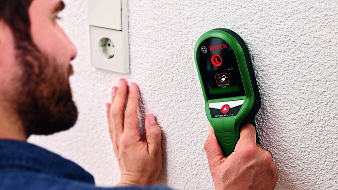 WG Zimmer einrichten: Mit einem Ortungsgerät Leitungen in der Wand finden, bevor Regale oder Bilder sicher montiert werden.