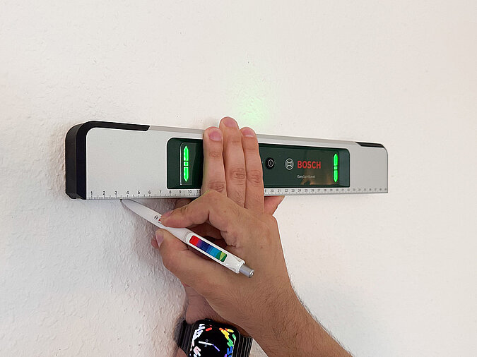 Bild mit Hilfe einer LED-Wasserwaage an Wand ausrichten