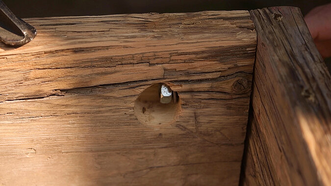 DIY-Bett aus Gerüstbohlen mit eingelassener Schraubverbindung und Metallwinkel in der Gerüstbohle