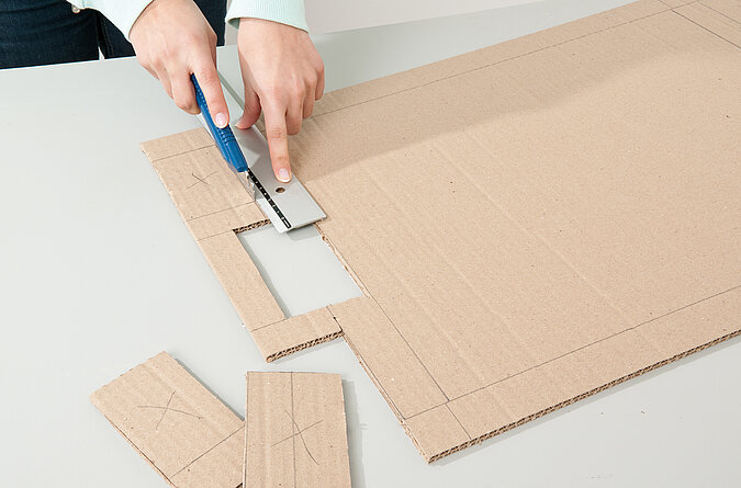 Tipp Kick basteln: Tore werden aus der Pappe mit einem Cuttermesser ausgeschnitten