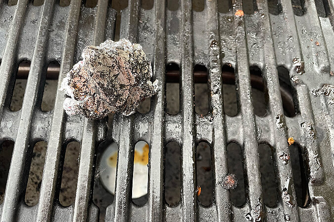Festival Gadgets DIY-Grillreinigung mit zusammengeknüllter Alufolie auf dem Rost für schnelles Säubern beim Camping