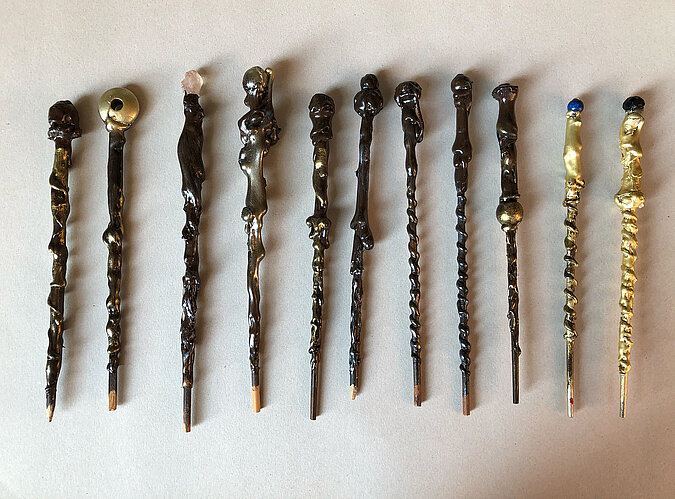 Selbst gebastelte Zauberstäbe aus Holz mit unterschiedlichen Verzierungen als Accessoire für ein Halloween-Kostüm.