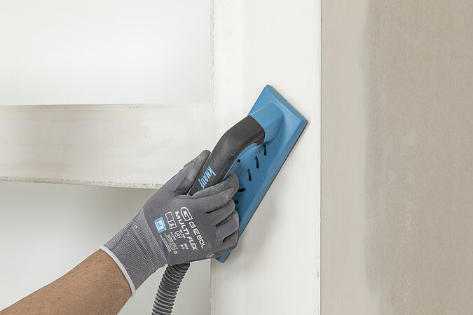 Wandnische Trockenbau: Verspachtelte Übergänge der Nischenverkleidung mit dem Handschleifer glätten.