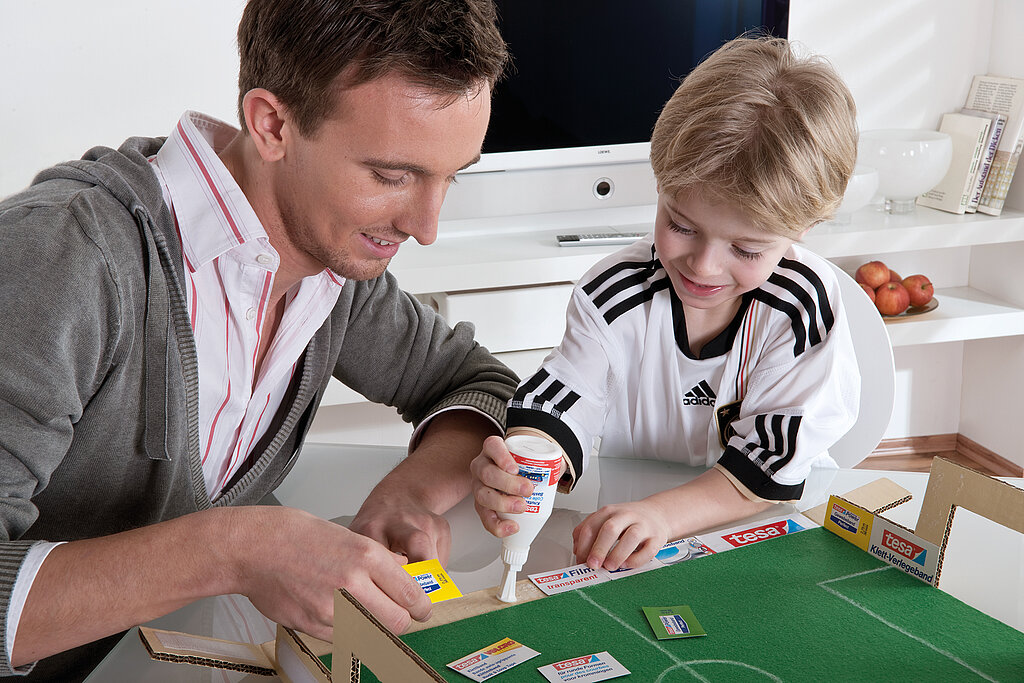 Tipp Kick basteln: Vater und Sohn bauen das selbst gebastelten Tipp Kick zusammen