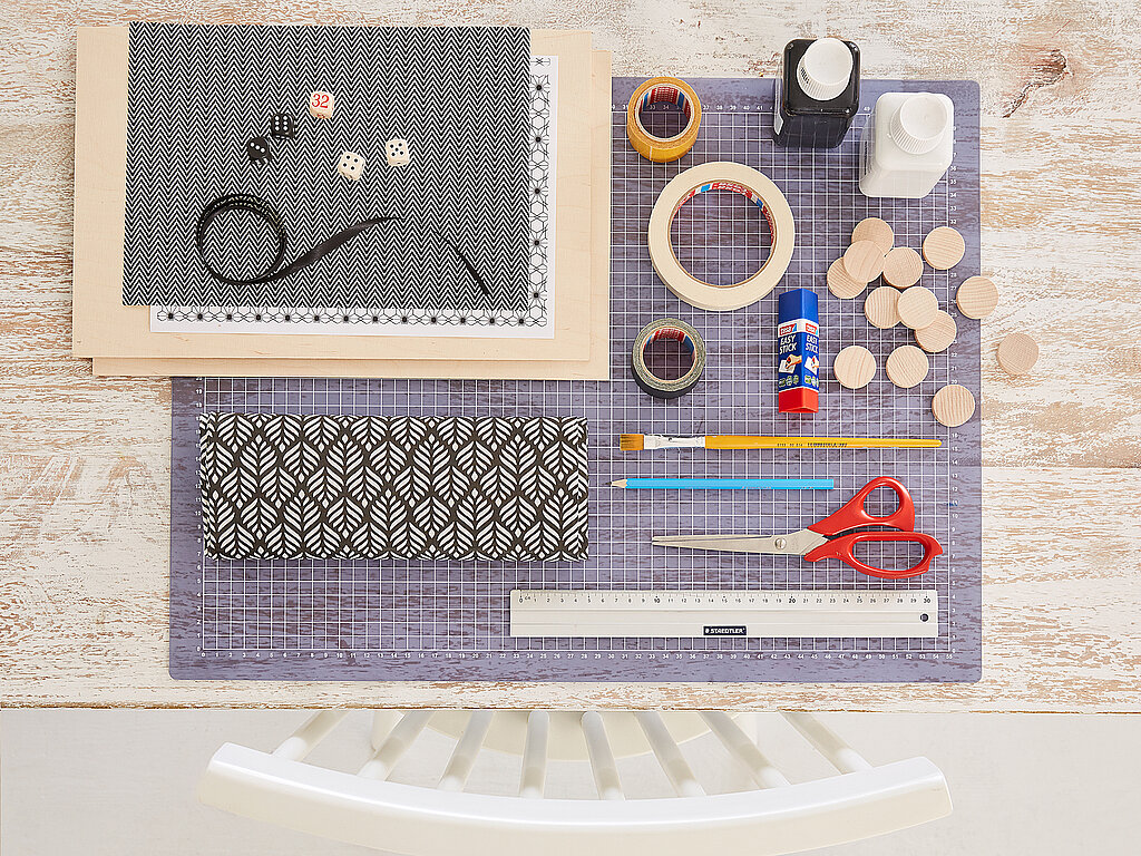 Backgammon Spiel: Materialübersicht mit Holzplatten, Wachstuch, Spielsteinen und Bastelzubehör.